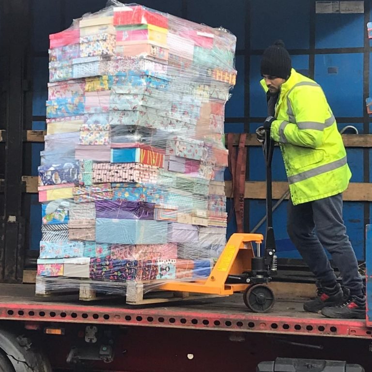 Pallet met kerstdozen wordt in een vrachtwagen geladen voor transport naar Roemenië